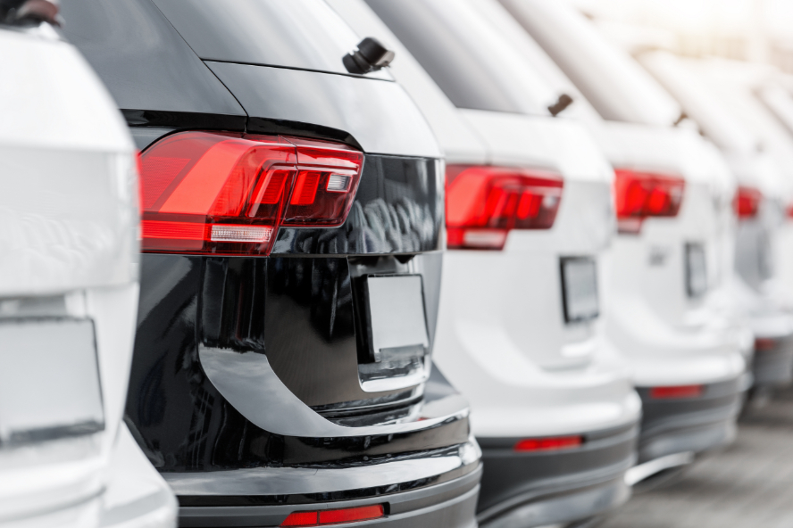 A back view of a row of SUVs on a dealership lot.