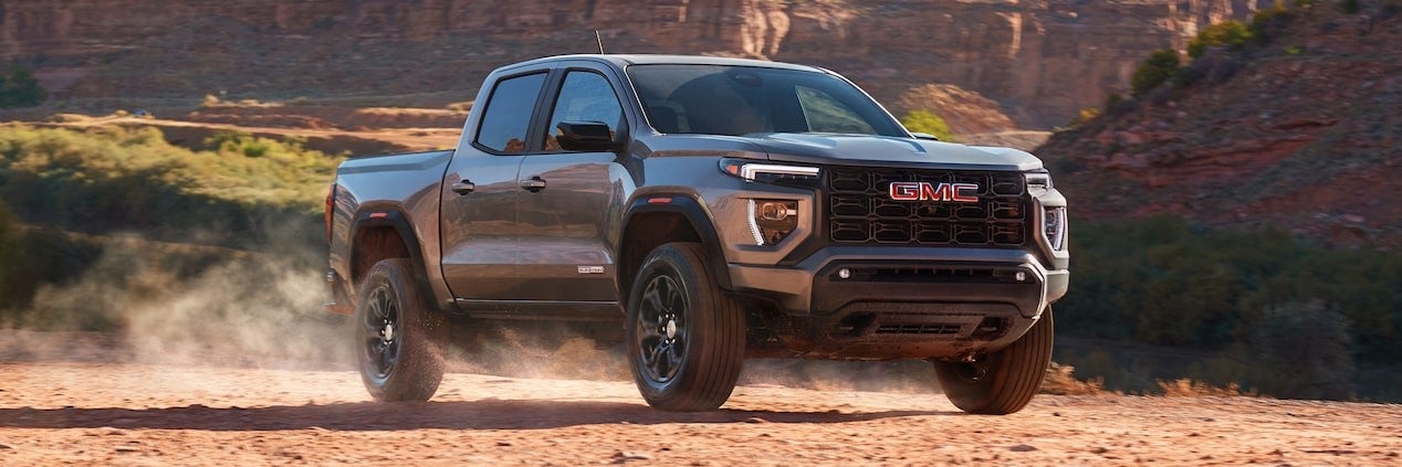 2025 GMC Canyon driving in a dusty valley