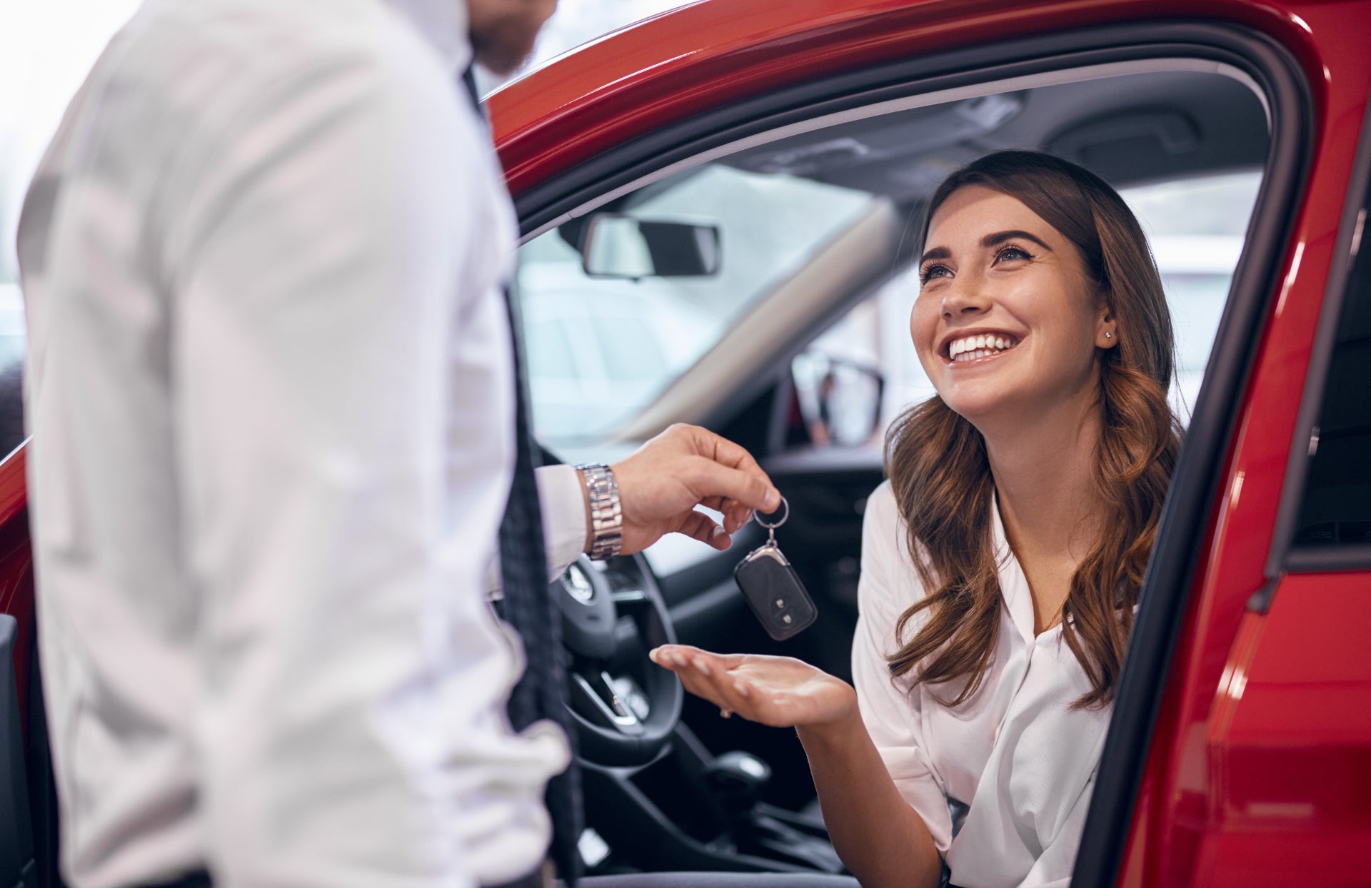 Smiling woman getting the keys to her new GMC