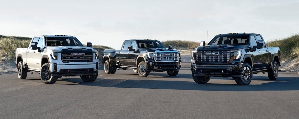 Three New GMC Sierra 2500 HD parked by a dune
