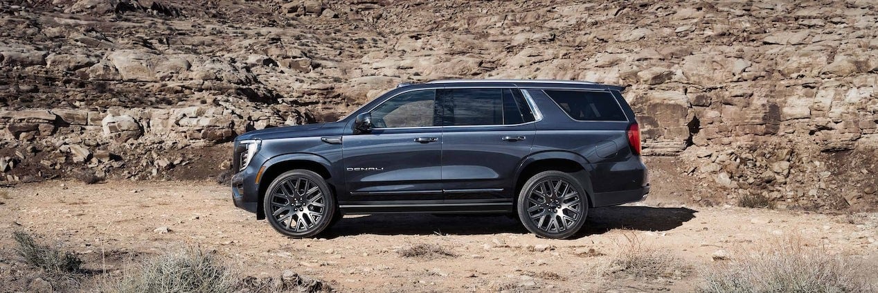 2025 GMC Yukon parked beside a rocky hill