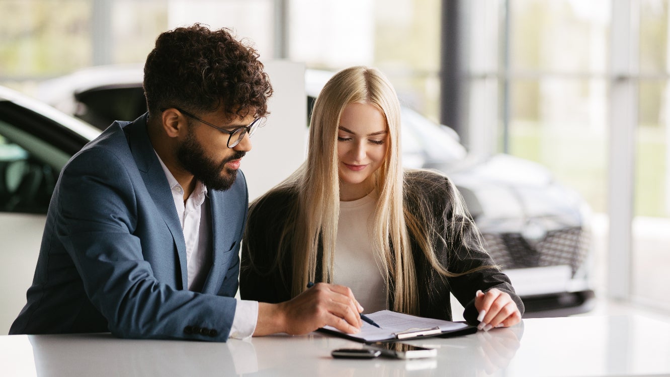 A car salesperson explaining a contract to a client.