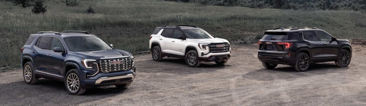 Three 2026 GMC Terrain SUVs parked on a gravel road